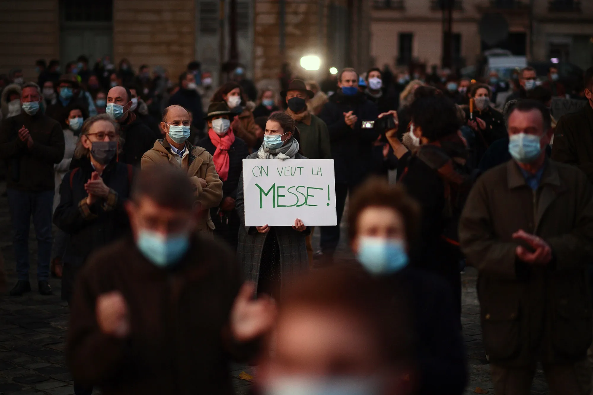 A woman holds a placard reading "We want the mass" in Versailles, Nov. 15.&nbsp;