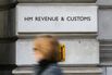 A woman walks past HM Revenue &amp; Customs building on