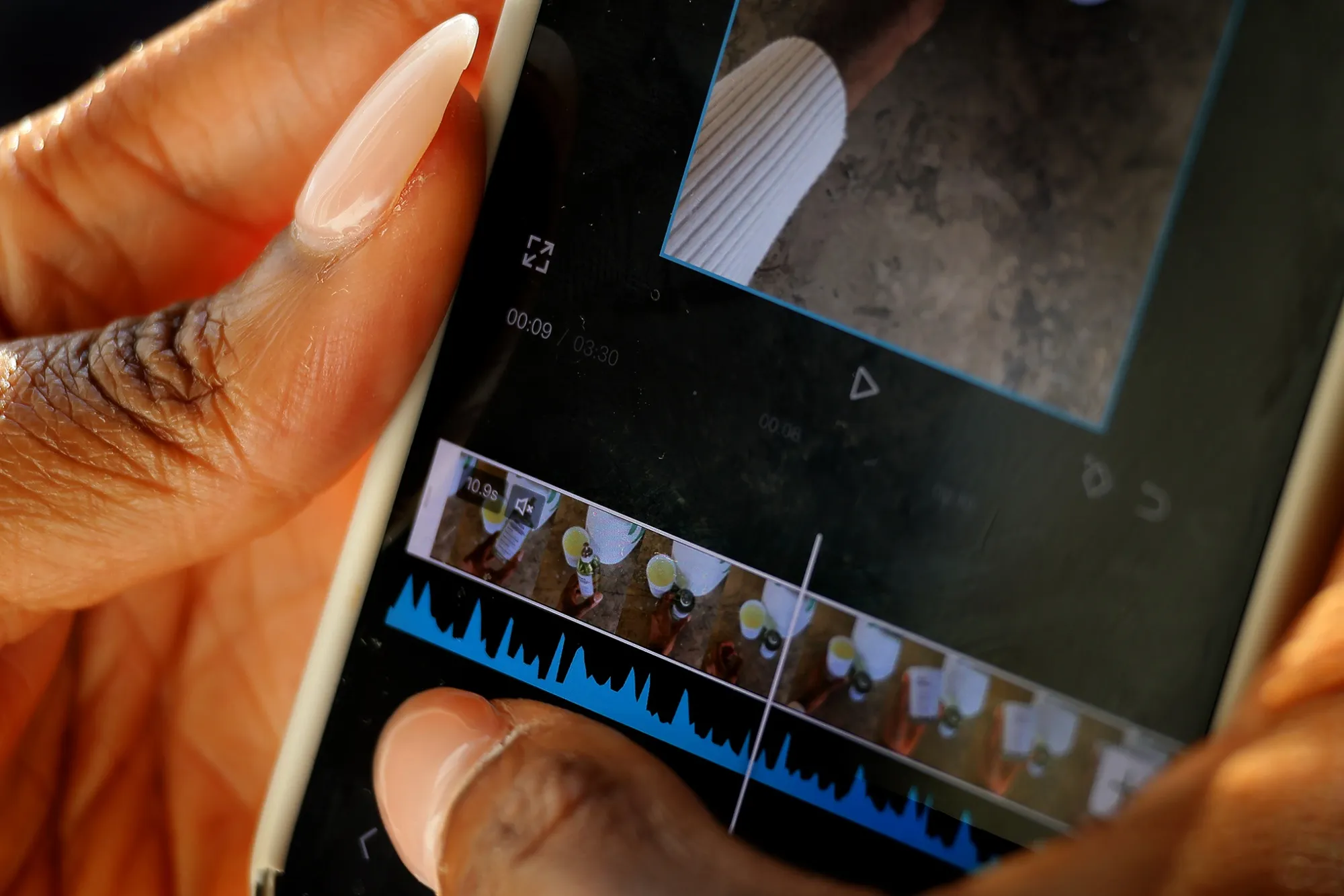 A woman edits a video with CapCut on her phone.