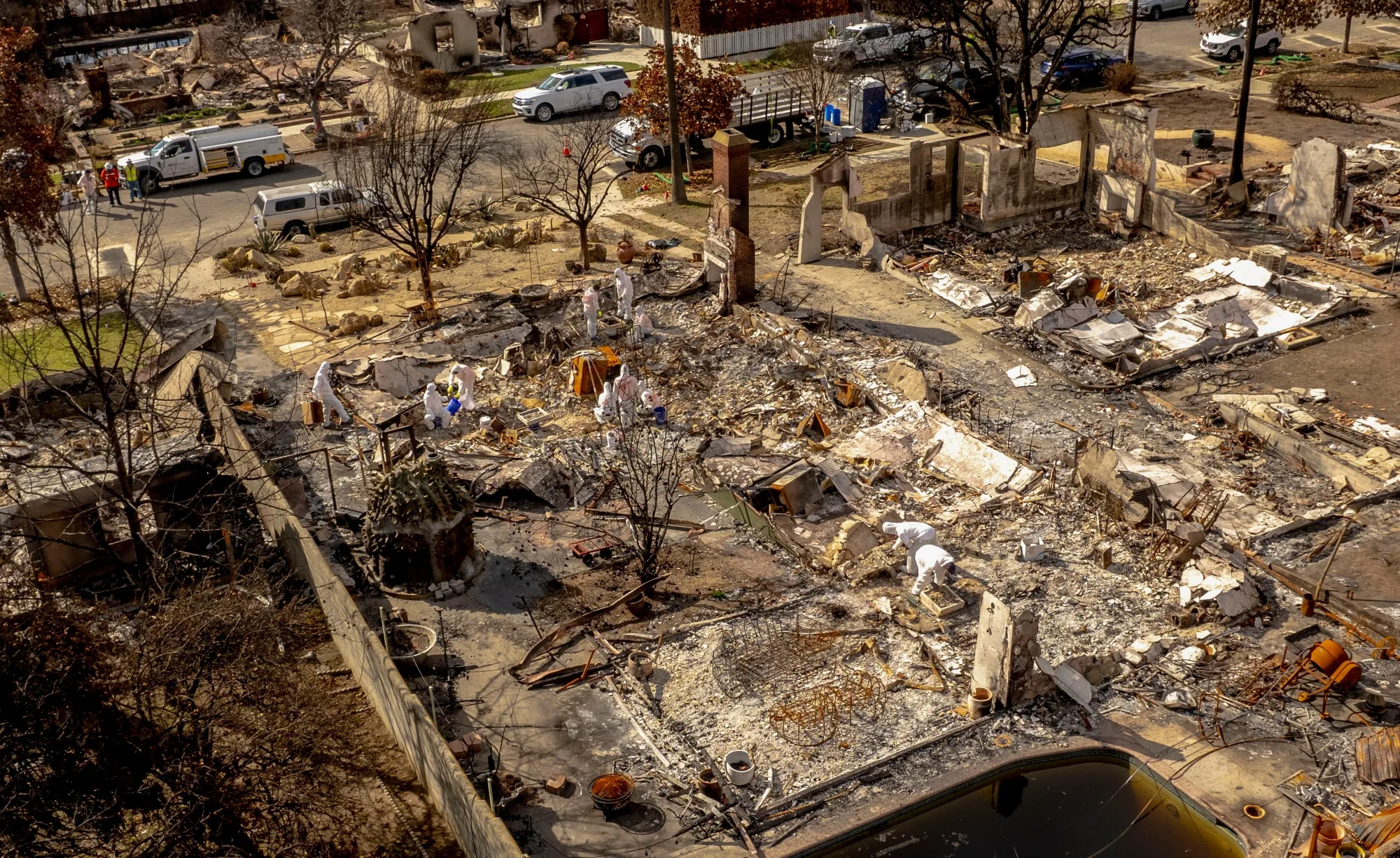 Private contractors remove debris from a home destroyed by the Eaton Fire in Altadena, California.