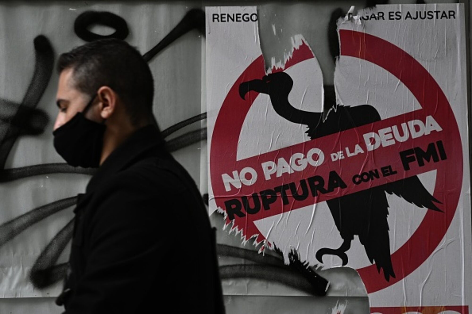 A man walks past a sign against paying the debt with the IMF in Buenos Aires