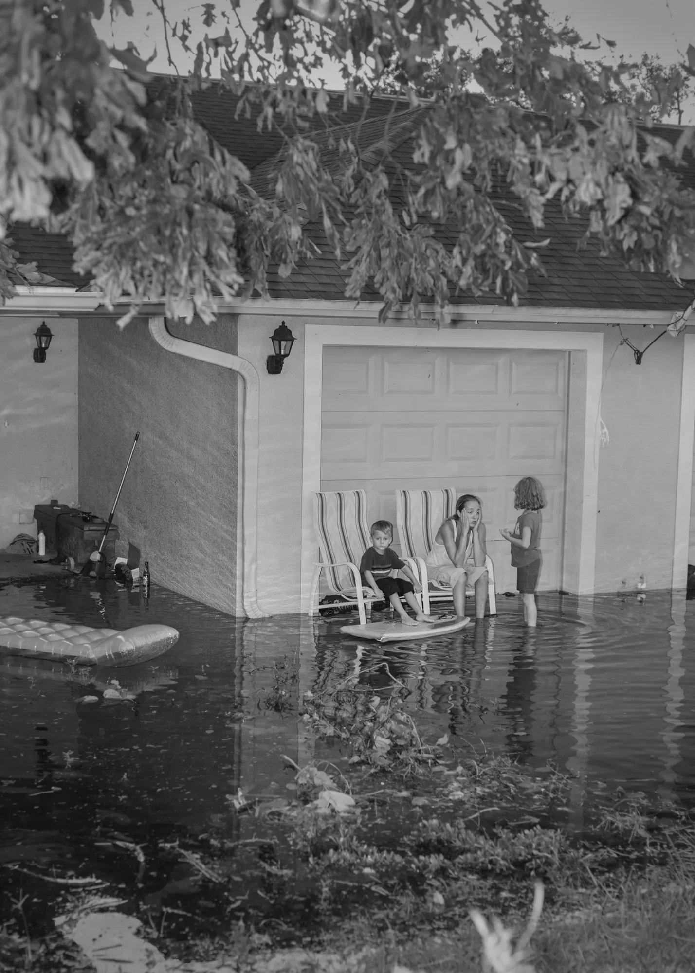 Ashley Waters (center), flanked by her children Jayden (left) and Julia, sits in front of their flooded home as water continues to rise a day after Hurricane Irma hit the region. The family stayed at their home during the storm and didn’t evacuate.