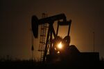 The silhouette of an electric oil pump jack is seen at dusk in the oil fields surrounding Midland, Texas, U.S., on Tuesday, Nov. 7, 2017. Nationwide gross oil refinery inputs will rise above 17 million barrels a day before the year ends, according to Energy Aspects, even amid a busy maintenance season and interruptions at plants in the U.S. Gulf of Mexico that were clobbered by Hurricane Harvey in the third quarter. Photographer: Luke Sharrett/Bloomberg