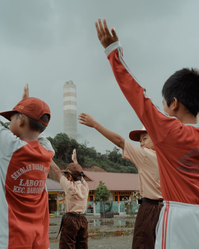 Children do their morning exercises at an elementary school in Labota, where IMIP is aggressively expanding.