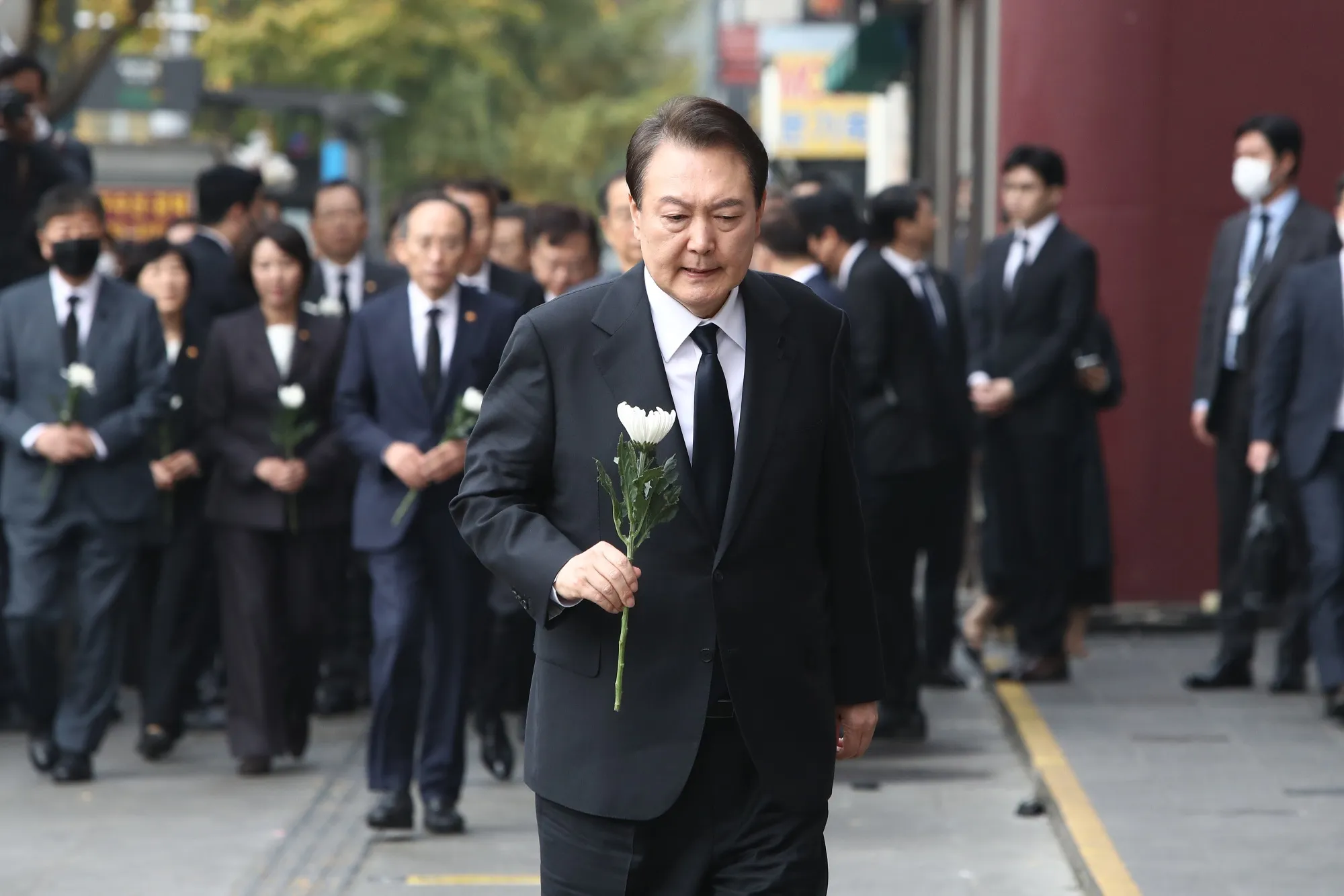 Yoon Suk-yeol holds a flower for the victims near the scene on Nov. 1.