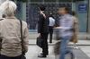 Pedestrians look an electronic stock board outside a securities firm in Tokyo, Japan, on Tuesday, May 7, 2019. Trading resumed Tuesday after a 10-day Golden Week holiday with a slew of news for investors to process.
