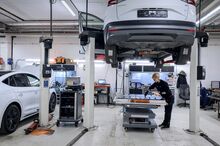A high-voltage technician working with open battery packs at the Moller Group facility.