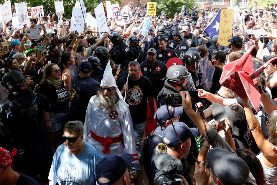 Riot police protect members of the Ku Klux Klan from counter-protesters as they arrive to rally in opposition to city proposals to remove or make changes to Confederate monuments in Charlottesville, Virginia.