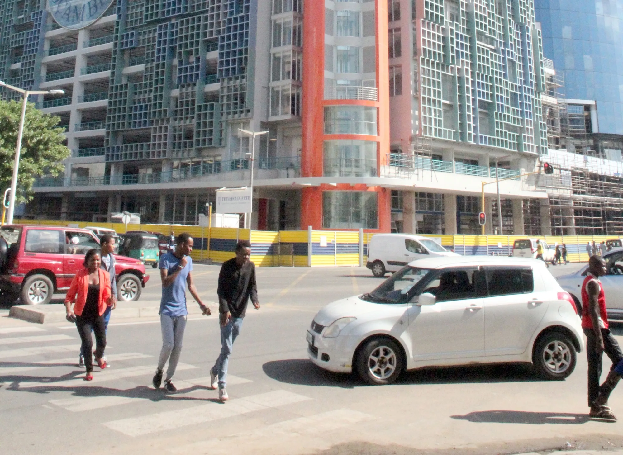 People walk in front of Mozambique central bank, in Maputo.
