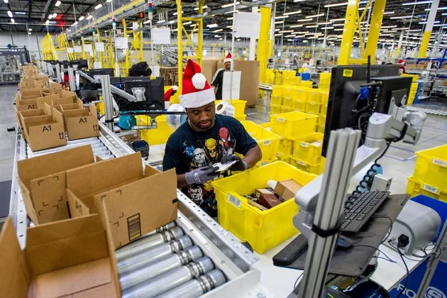 Amazon.com employees load boxes with orders at the company’s fulfillment center in Tracy, Calif., on Nov. 30.