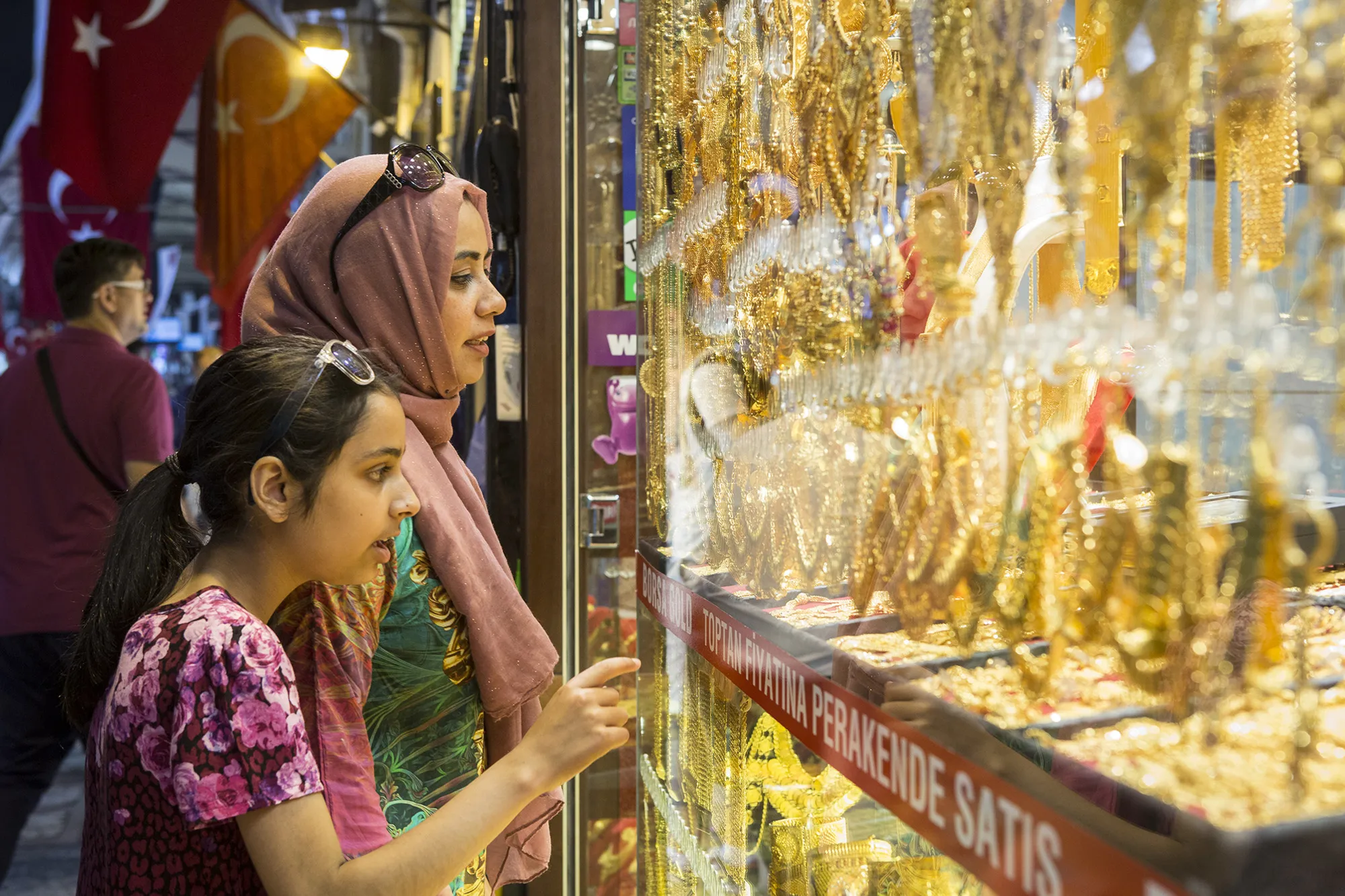 Customers browse gold in the window of a store in a shopping arcade at the Grand Bazaar in Istanbul.