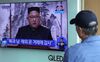 A man watches a television screen showing a broadcast featuring North Korean leader Kim Jong-un.