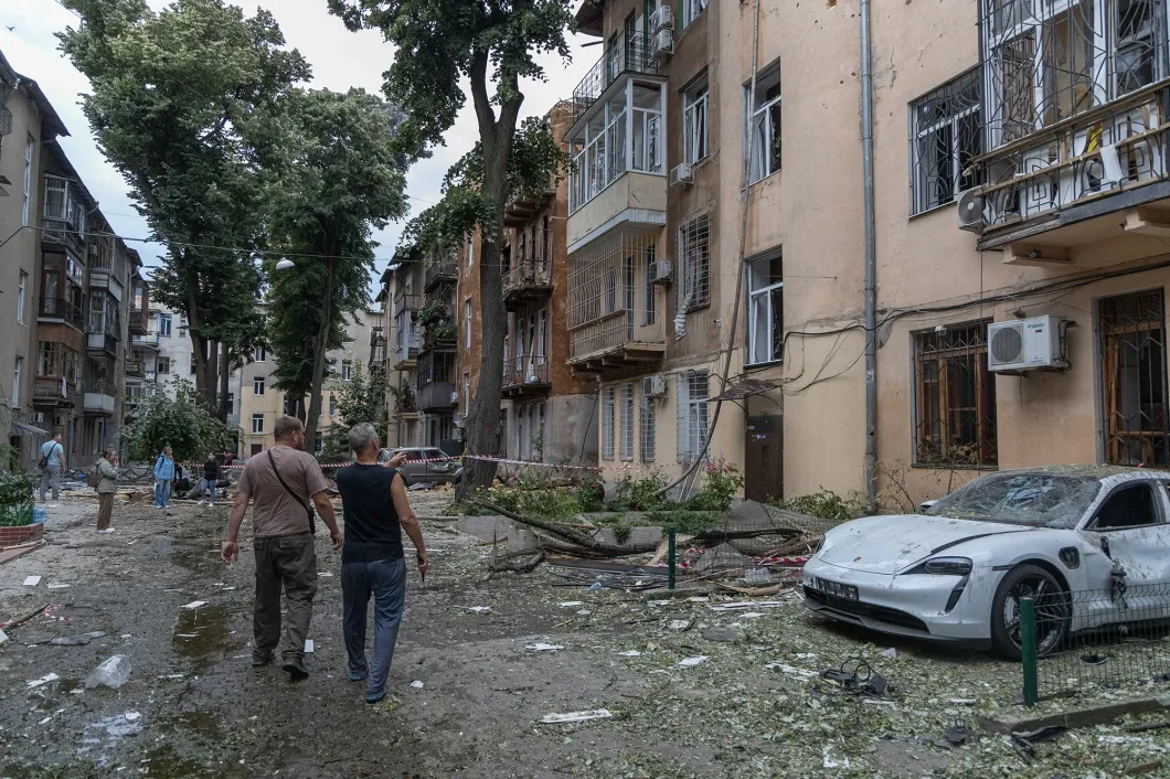 Local residents look at damaged residential buildings following aa Russian drone attack in Odesa, on June 20.