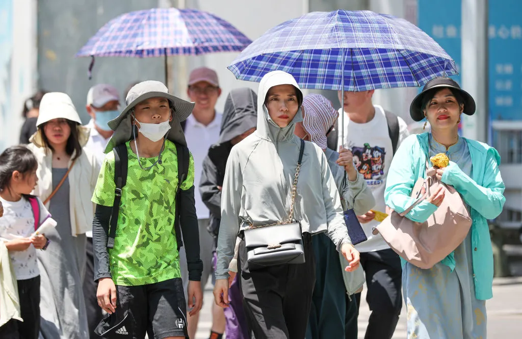 Pedestrians&nbsp;shade from the sun in&nbsp;Beijing, July 6.&nbsp;