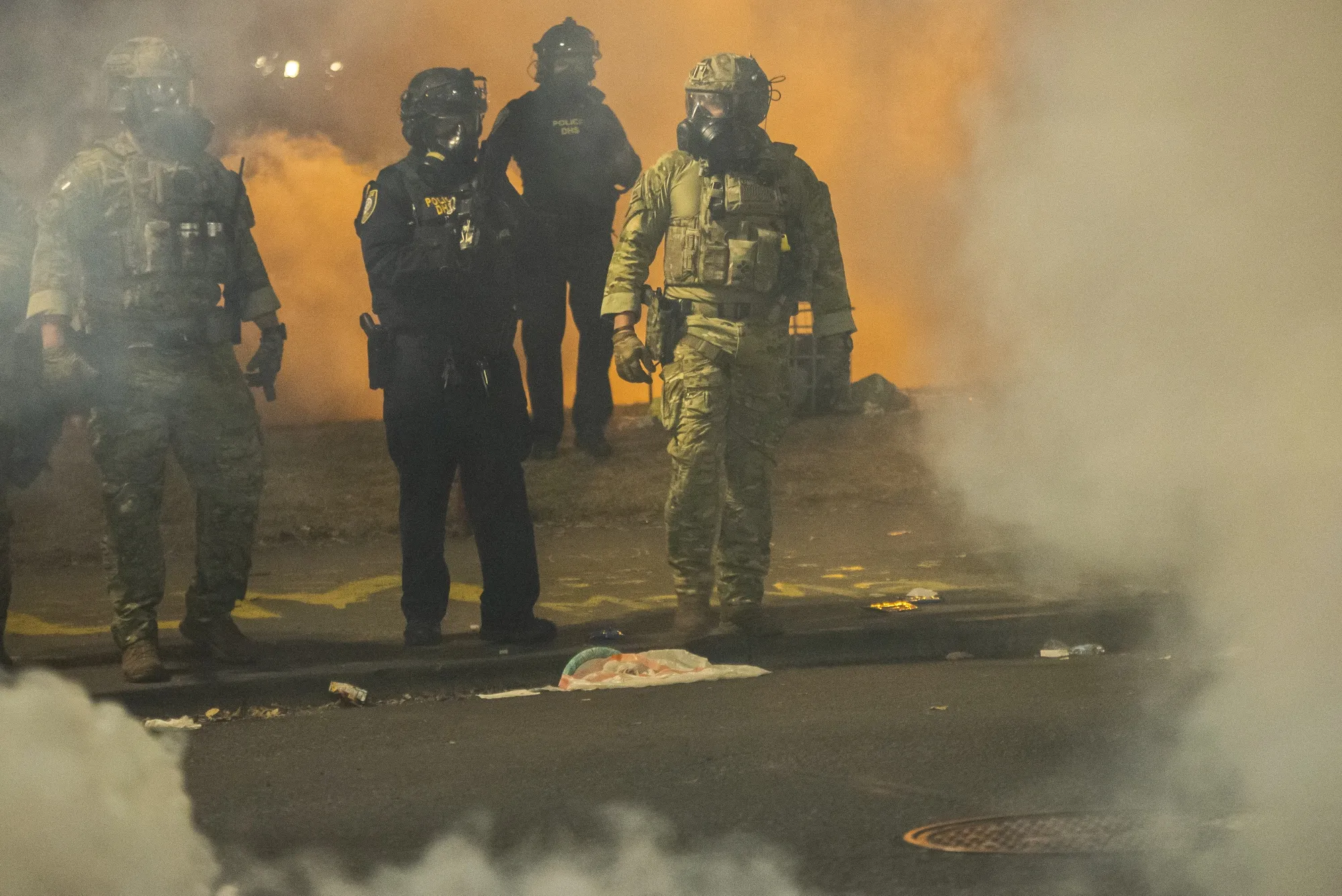 Federal police walk through tear gas while dispersing a crowd of protesters in Portland, Oregon.&nbsp;