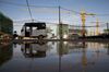An auto rickshaw is reflected in a puddle of water as a crane operates at a construction site in Sihanoukville, Cambodia, on Monday, July 8, 2019. In Sihanoukville, a once-sleepy resort town, Cambodians are betting that an infusion of Chinese-built infrastructure will pay off with jobs and prosperity. The influx is tied to China’s Belt and Road Initiative, an ambitious plan to build an estimated $1 trillion worth of infrastructure across Asia and parts of Africa, dwarfing the post-World War II Marshall Plan.