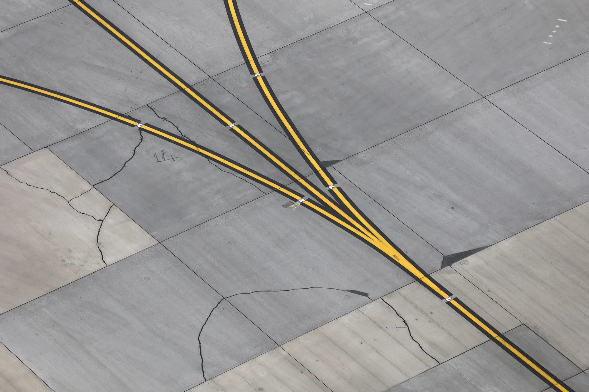 Cracks form on the paved surface near runways at London Heathrow airport.