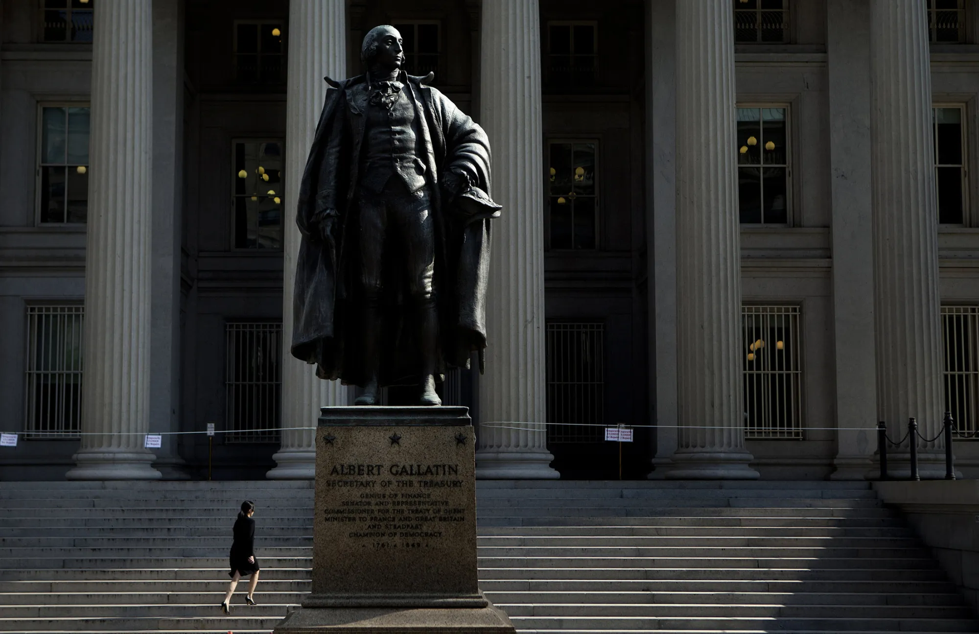 A woman walks past a statue of Albert Gallatin, the 4th Secretary of the U.S. Treasury, while entering the Treasury building in Washington, D.C.
