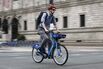 A Boston cyclist passes by the Copley Square shuttle drop-off on Aug. 22, after the MBTA shut down the Orange Line for service repairs.