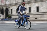 A Boston cyclist passes by the Copley Square shuttle drop-off on Aug. 22, after the MBTA shut down the Orange Line for service repairs.