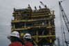 Employee pass in front of the finished Abkatun-A2 oil platform at the Mcdermott International Inc. fabrication facility in Altamira, Tamaulipas state, Mexico, on Friday, Nov. 2, 2018. Mcdermott International was awarded the $454 million contract for engineering, procurement, construction and installation for Abkatun-A2 from Petroleos Mexicanos (Pemex) in 2016. Pemex is expected to start operating the oil platform in April 2019.
