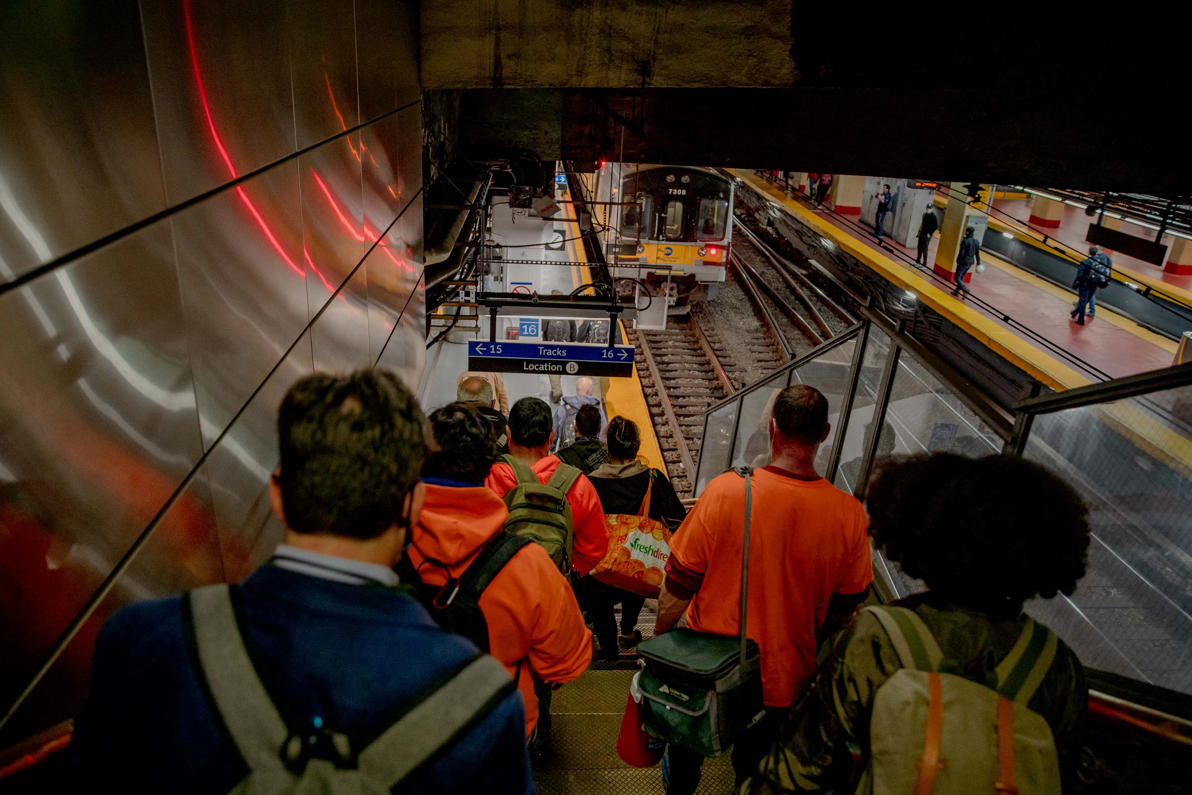 Commuters walk toward a Long Island Rail Road train at New York City’s Penn Station.