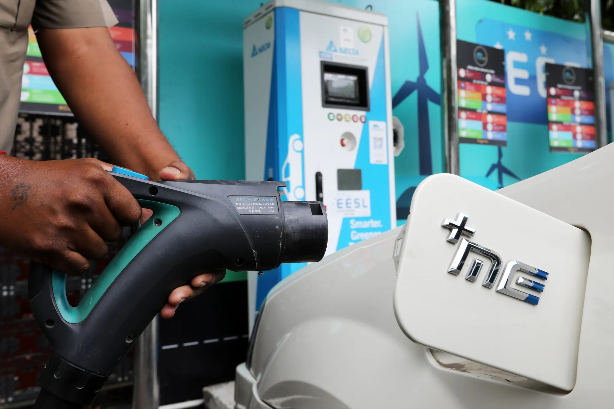 A charging plug is connected to an electric vehicle in New Delhi, India.