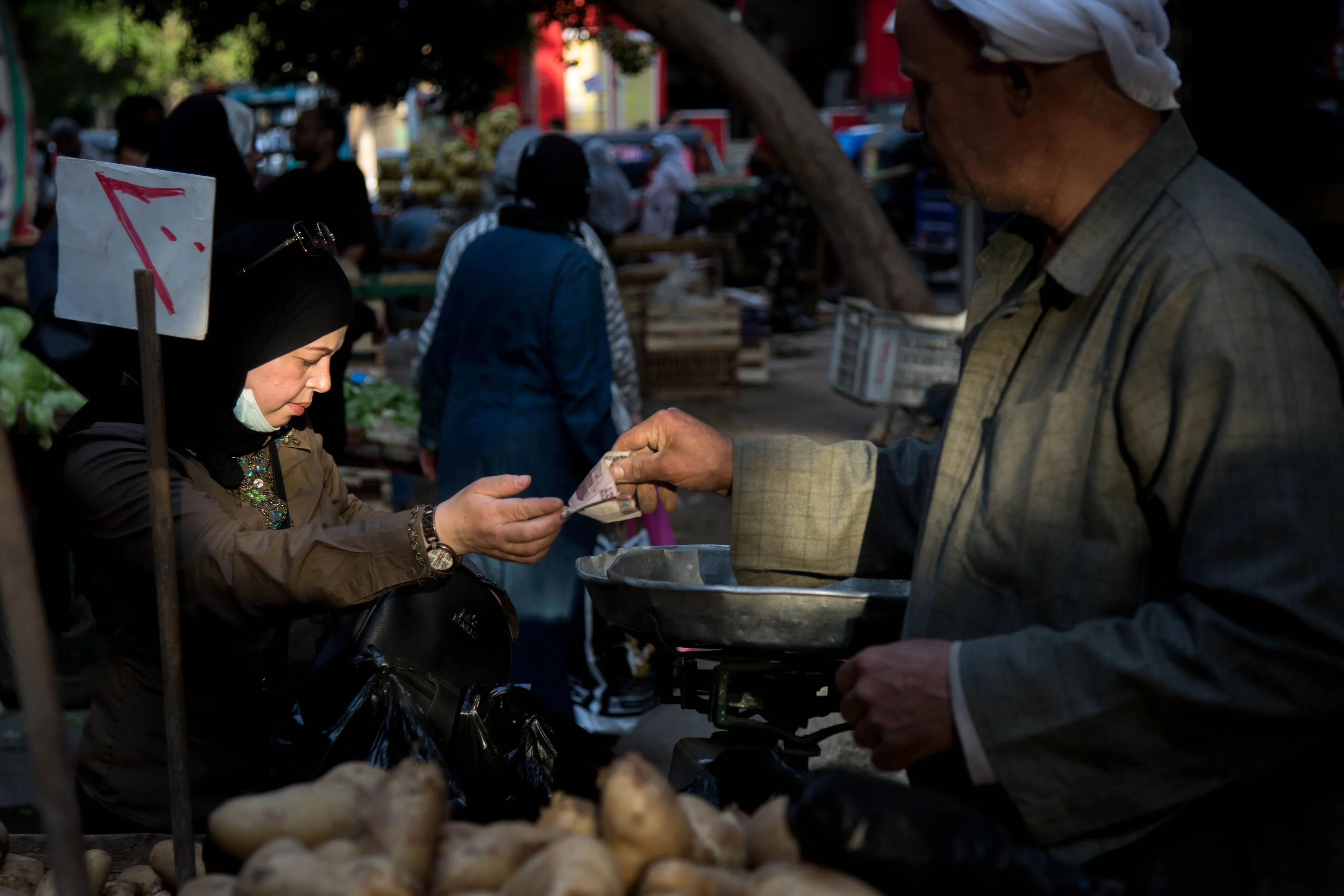 A customer pays a vendor for fresh vegetables at the Al-Monira market in Cairo, Egypt.
