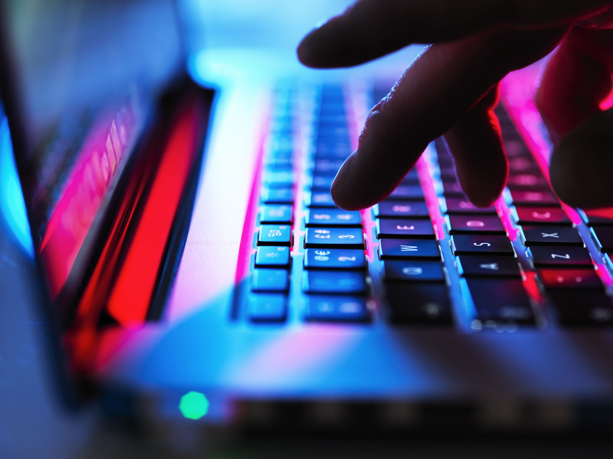 Man typing at his laptop computer at night. Photographer: Westend61/Getty Images