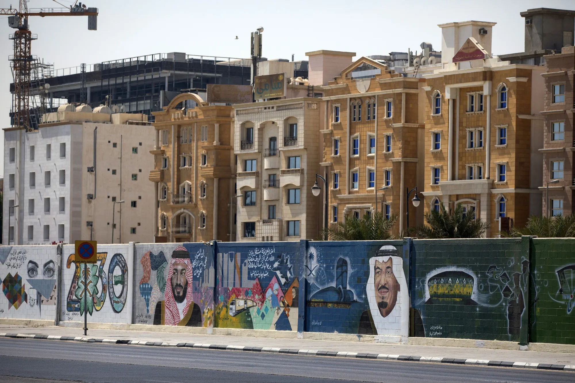 A wall mural displays the '2030 Vision' logo in front of a row of residential properties in Dhahran, Saudi Arabia.&nbsp;