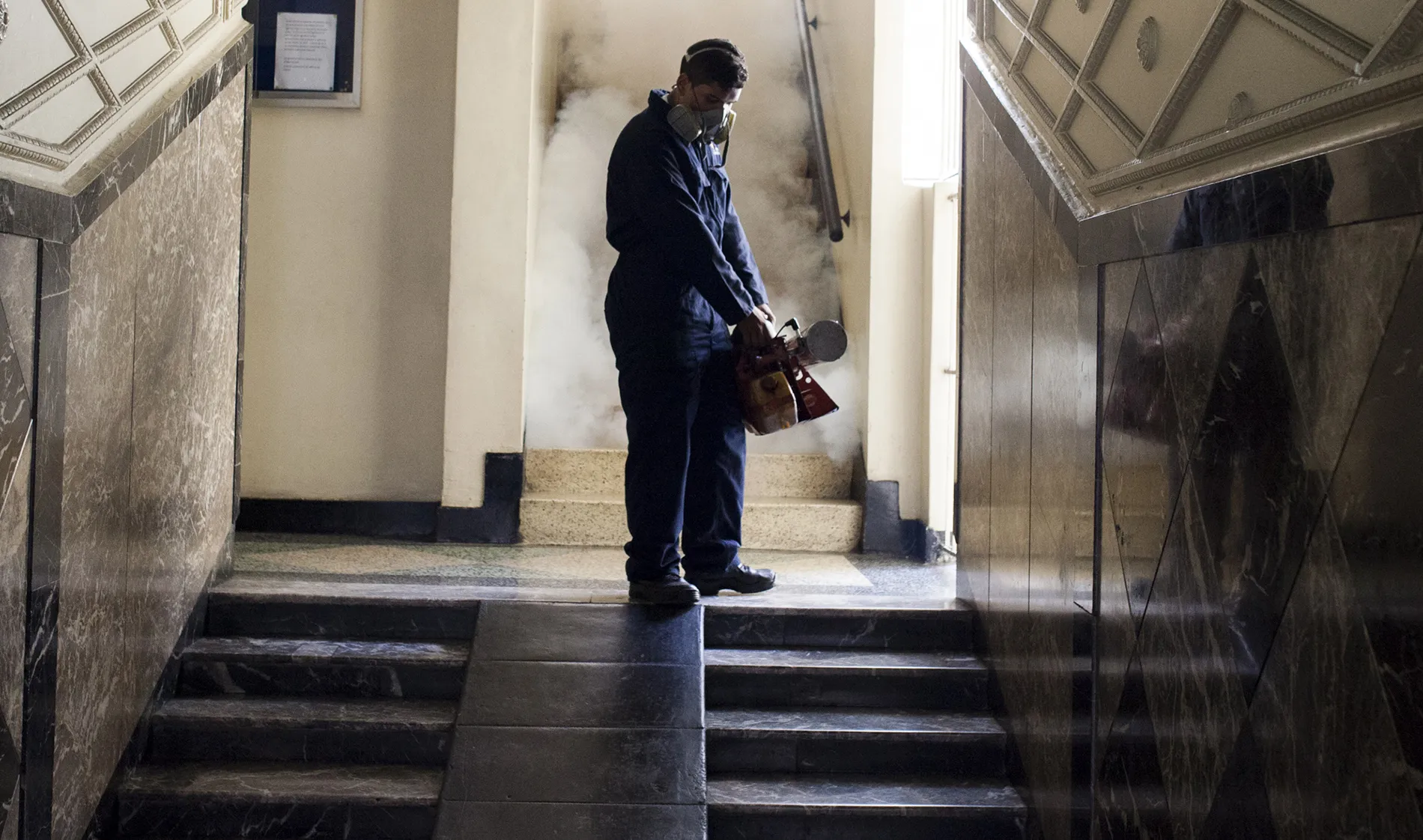 A worker fumigates the hallway of a building to eradicate mosquitoes in Caracas, Venezuela.
