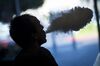 A customer exhales vapor from an electronic cigarette at the NXNW Vapor store in Sacramento, California, U.S., on Thursday, June 28, 2018.