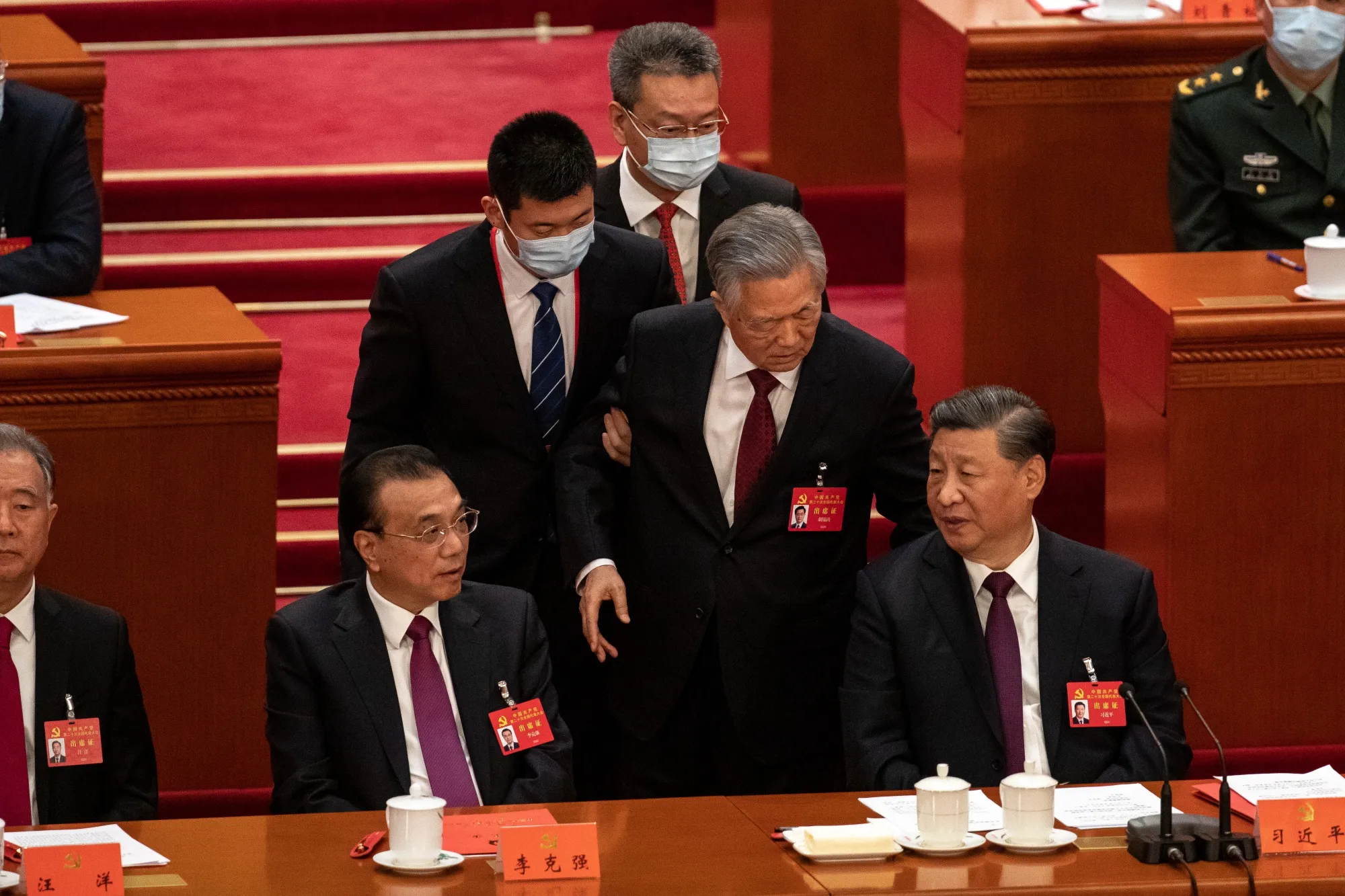 Hu Jintao, center, speaks with Xi Jinping, right, prior to leaving the conference hall on Oct. 22.