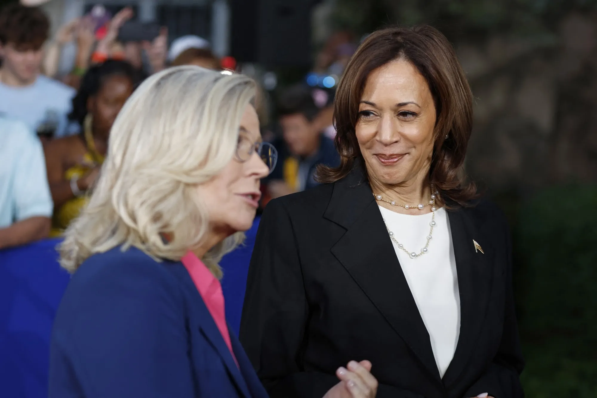 Kamala Harris listens to Liz Cheney speak to the press following a campaign event in Ripon, Wisconsin, on Oct. 3.