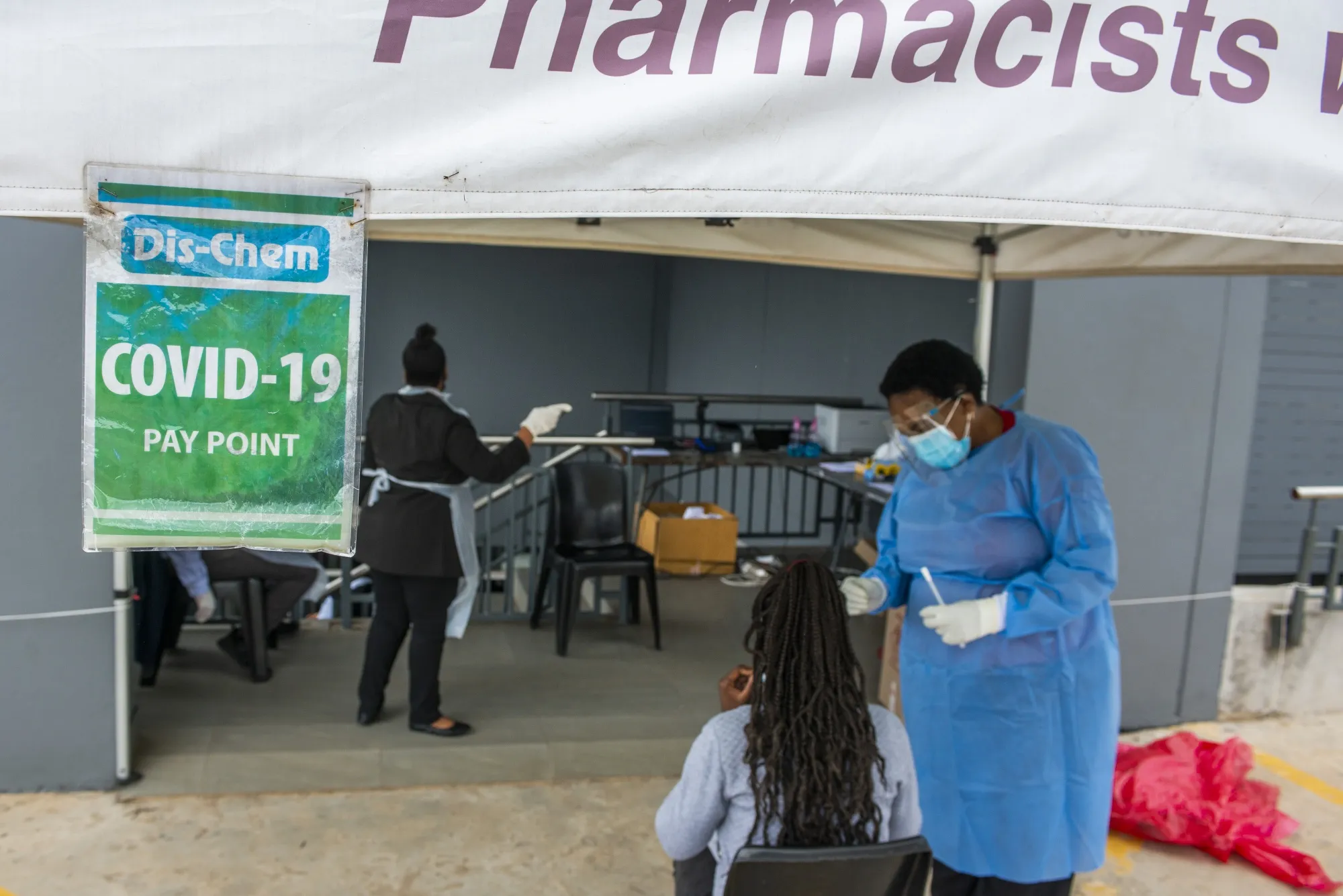 A medical worker speaks with a patient at a walk-in and drive-thru coronavirus testing facility in Pretoria.