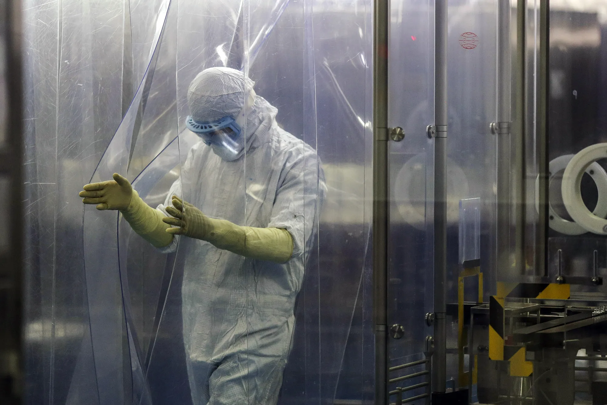 An employee in protective clothing exits an area of a research and development in Bengaluru, India.