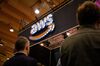 People pass by AWS (Amazon Web Services) stand during a Web Summit technology conference.