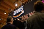 People pass by AWS (Amazon Web Services) stand during a Web Summit technology conference.