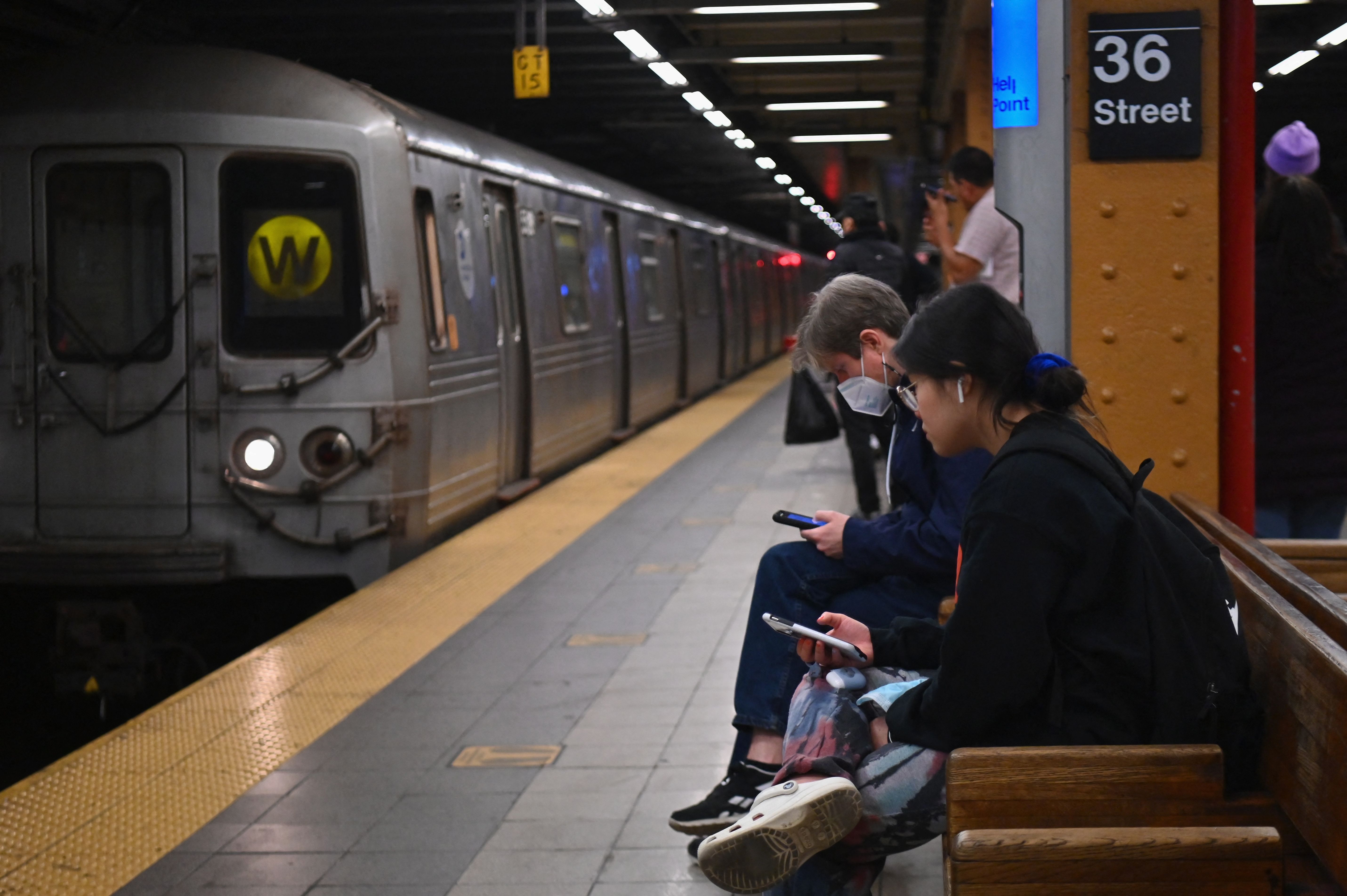 Commuters await a train at a subway station in New York.