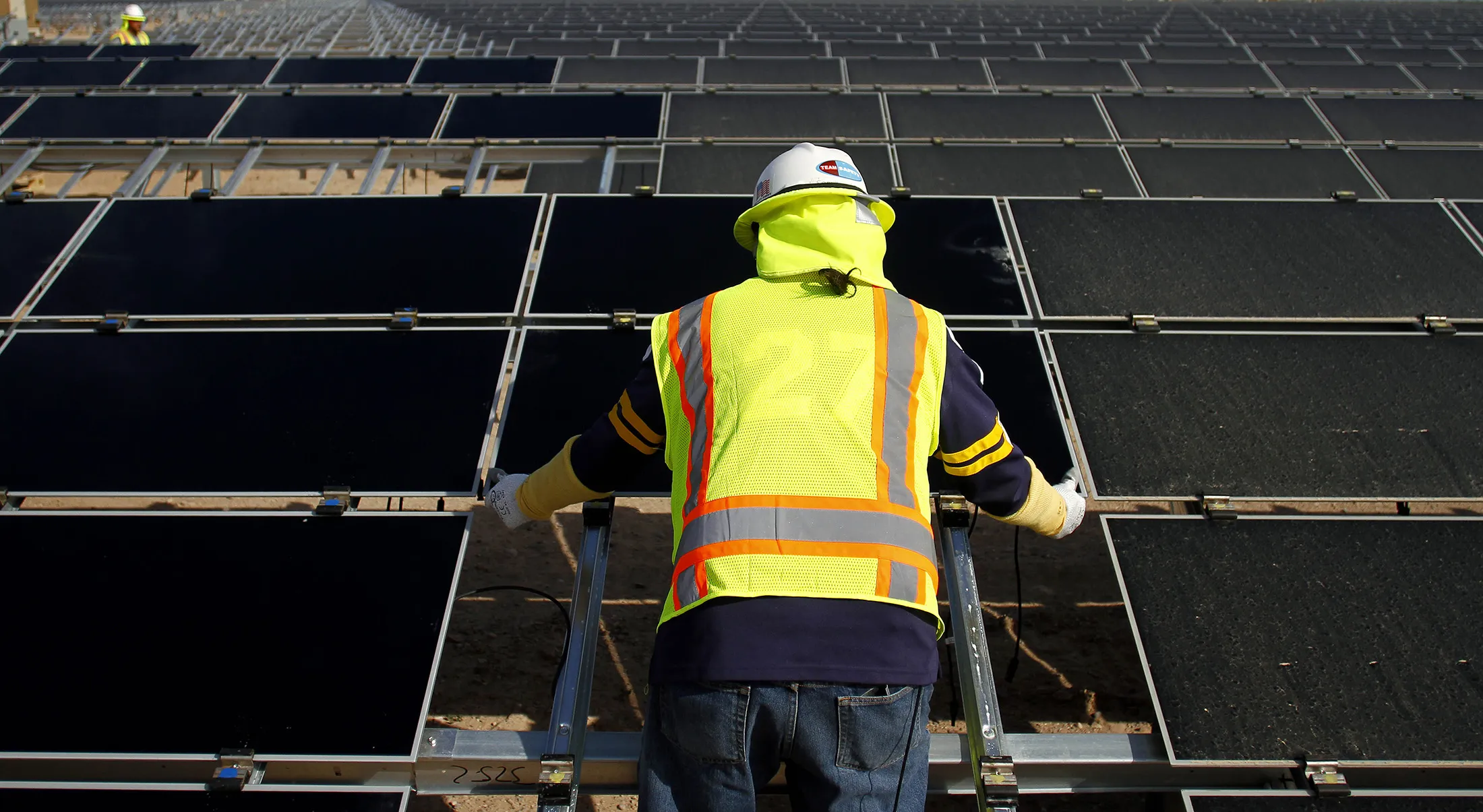 A worker installs First Solar Inc. photovoltaic solar panels
