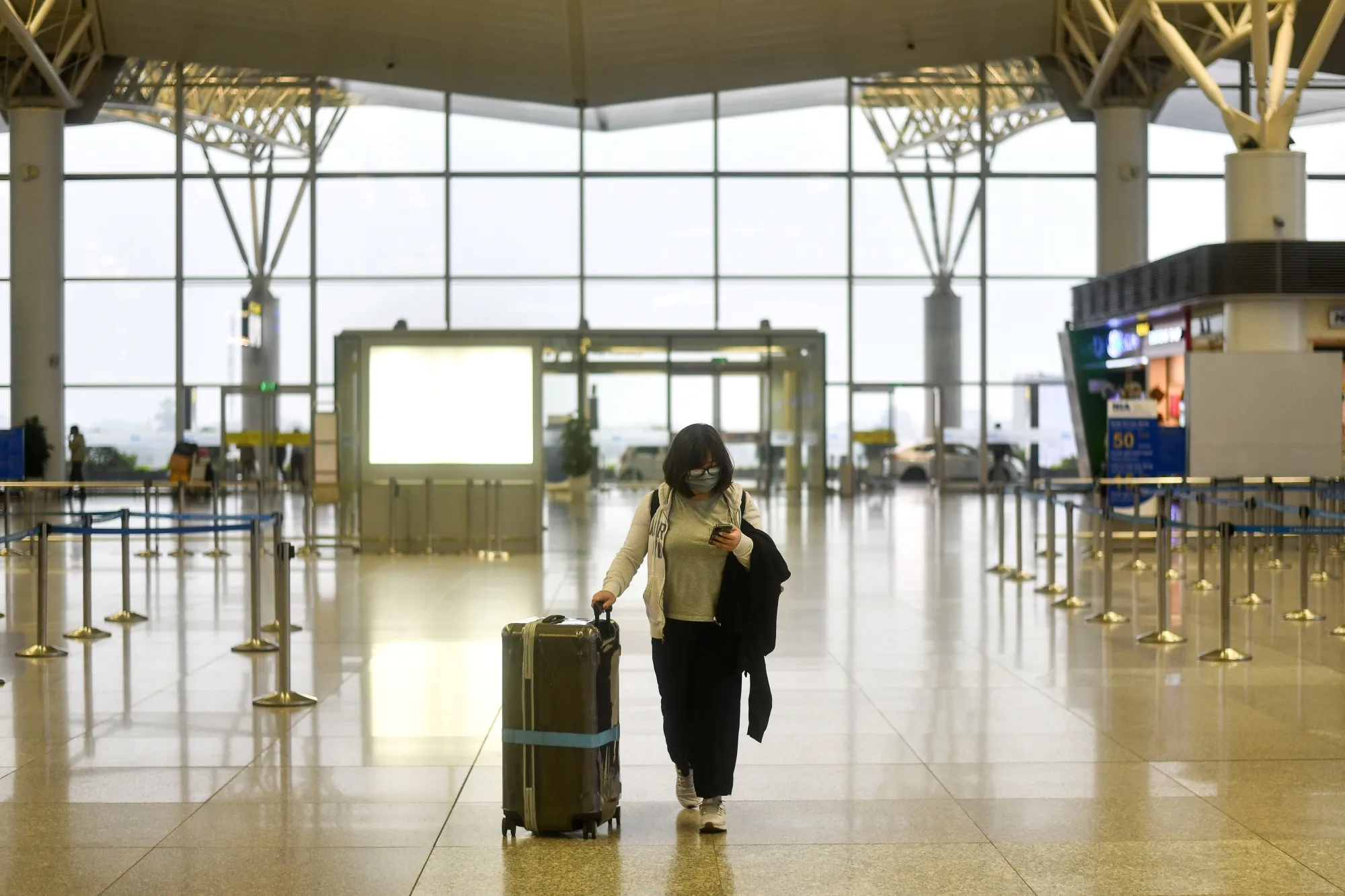A passenger wearing a face mask walks in the nearly empty departure hall of Noi Bai International Airport in Hanoi on March 12.