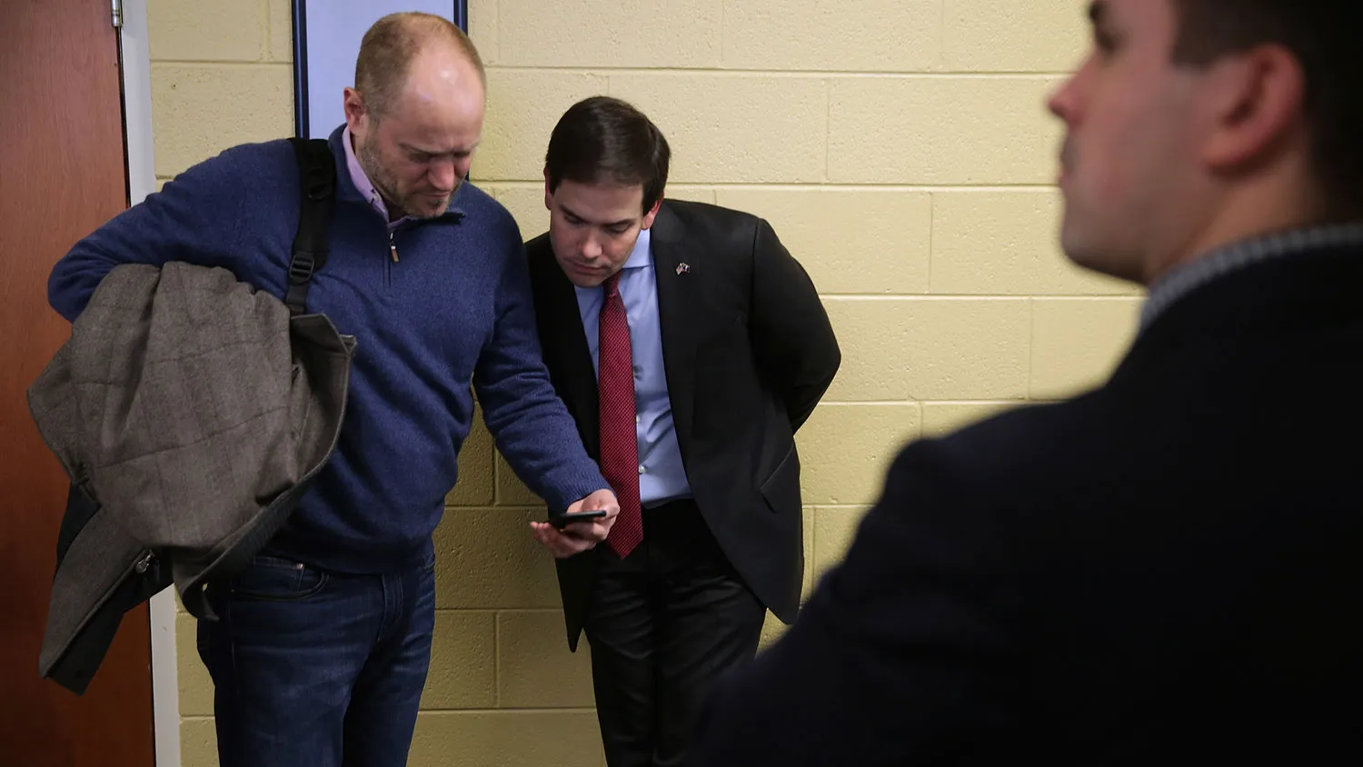 Republican presidential candidate Marco Rubio and adviser Todd Harris look at news reports about the campaign on Harris' phone before a town hall meeting at the Southside Christian School on Feb. 11, 2016, in Simpsonville, South Carolina.
