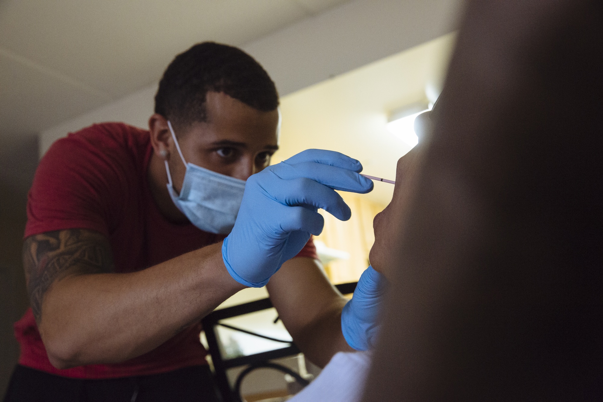 Ready paramedic Abel Collado performs a Covid-19 swab test on a patient during a home visit.