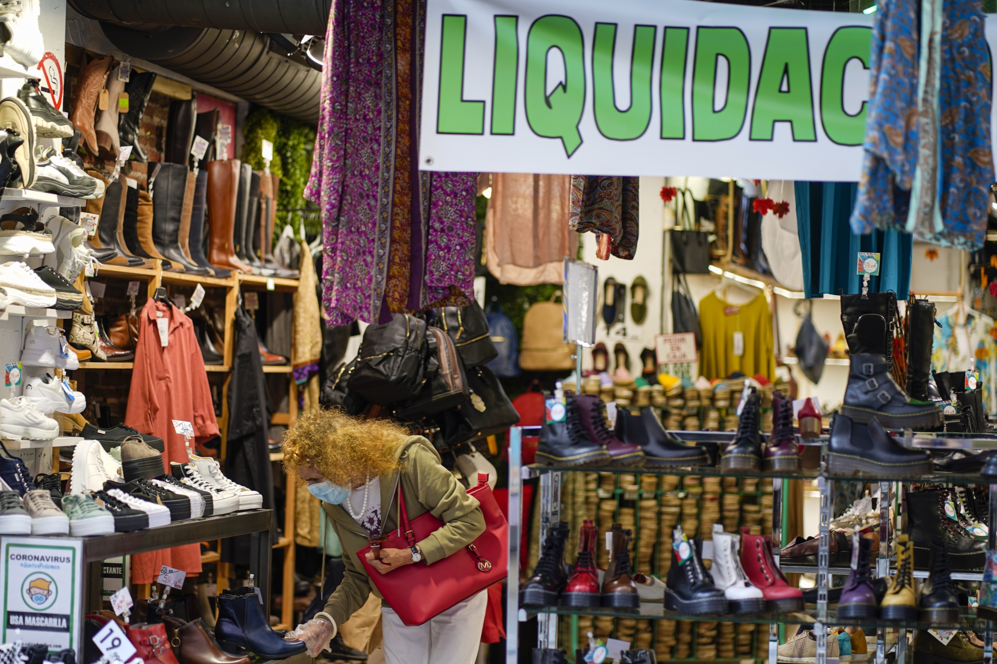 A shopper browses shoes at a store in Madrid.