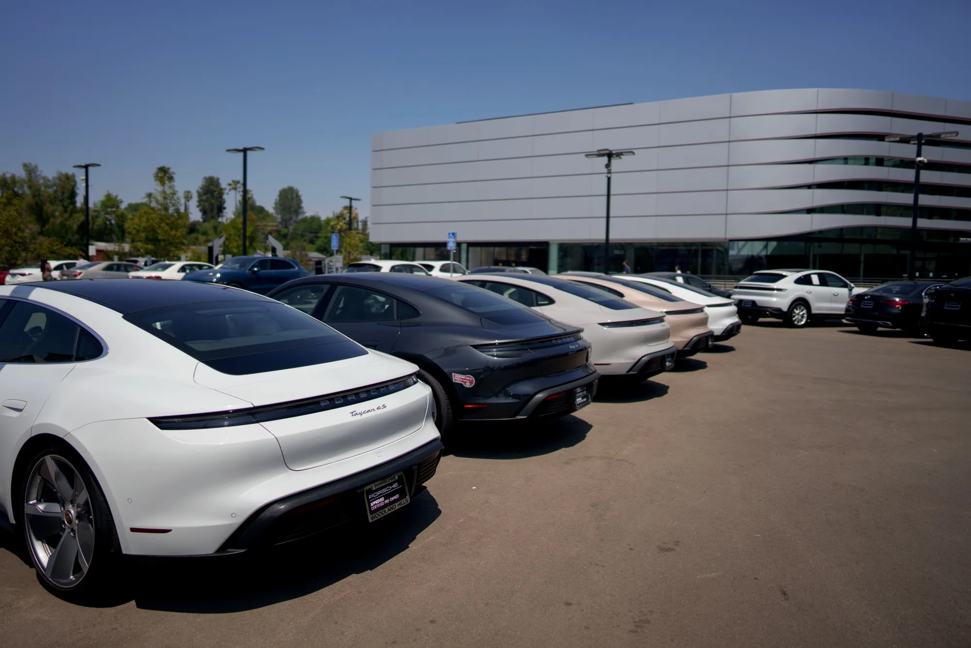 New Porsche vehicles for sale at a Porsche dealership in Los Angeles.