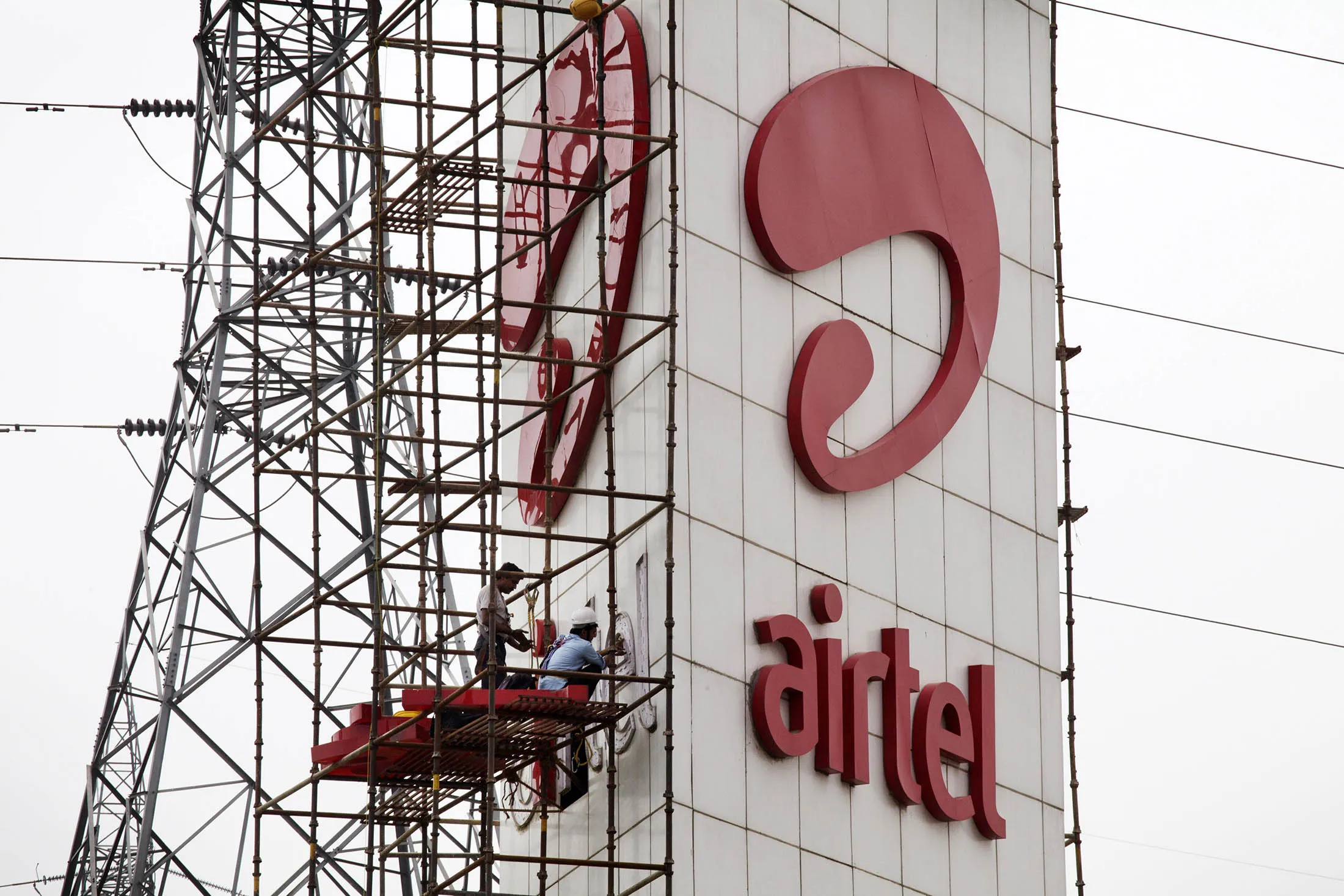 Workers install Bharti Airtel Ltd. signage in Gurgaon, India.
