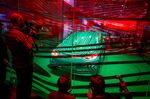 Motoring journalists take pictures of a Volkswagen ID 3 electric car in a glass cage during a press conference in Berlin.