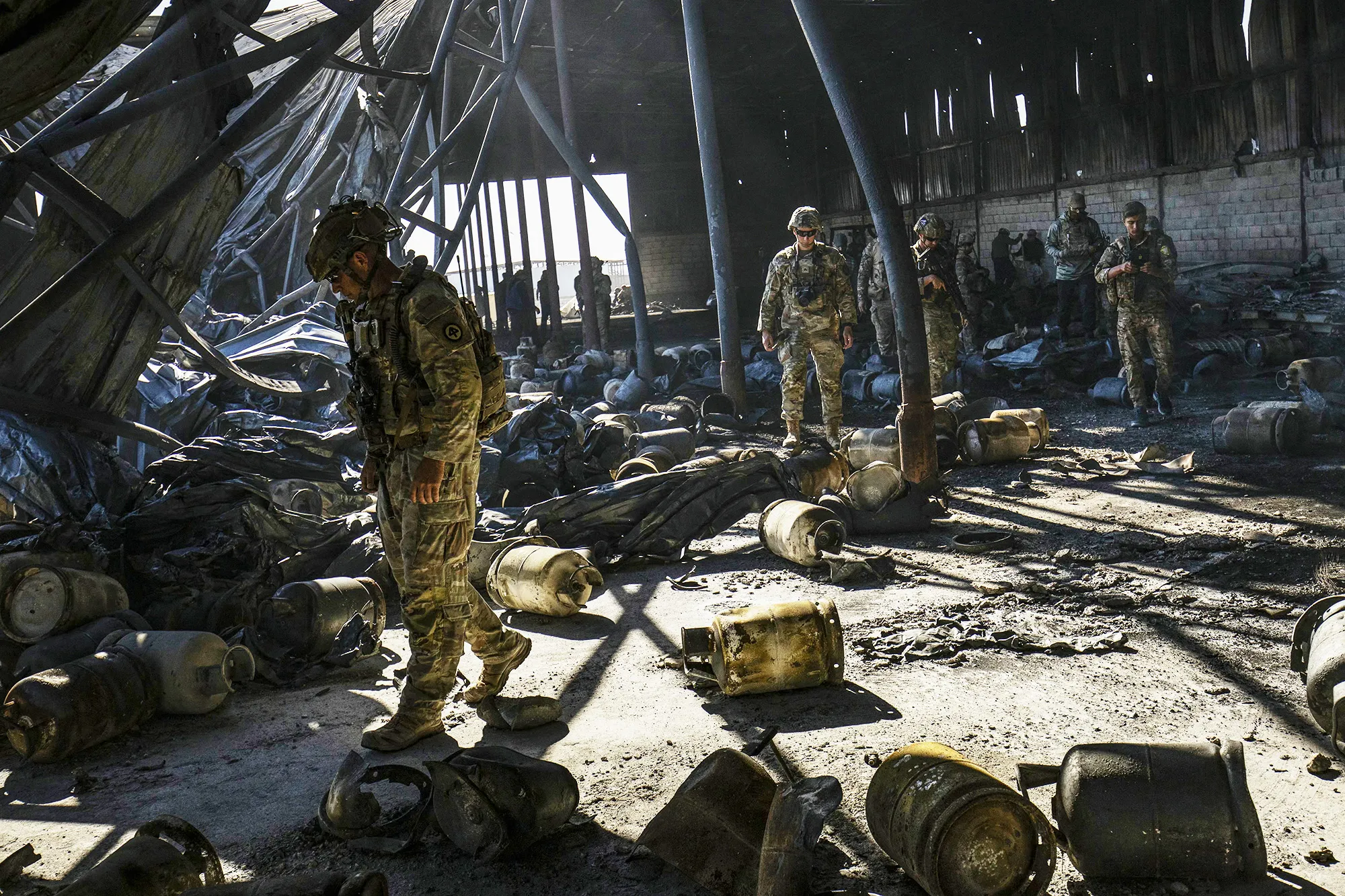 US soldiers inspect the site of a shelling from days earlier on an oil extraction facility near&nbsp;Rumaylan, Syria, on Oct. 28.