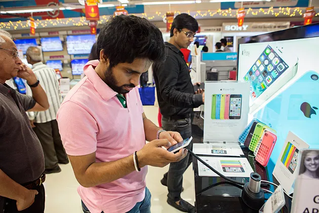 A customer tries out an Apple iPhone 5C at a Reliance Digital store in New Delhi on Nov. 2