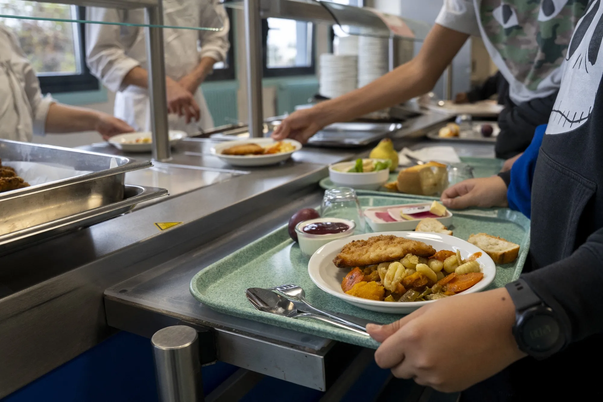 Teenagers help themselves to food in the school cafeteria.